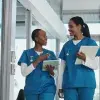 Deux infirmières marchent et se parlent en souriant