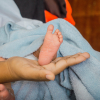 pied d'un bébé prématuré dans la main de son parent